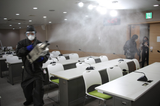 최근 정부서울청사 3층에 입주한 개인정보보호위원회 직원 가족이 코로나19 확진으로 판정되자 브리핑실에도 긴급 방역 소독을 하고 있다.   [연합뉴스]